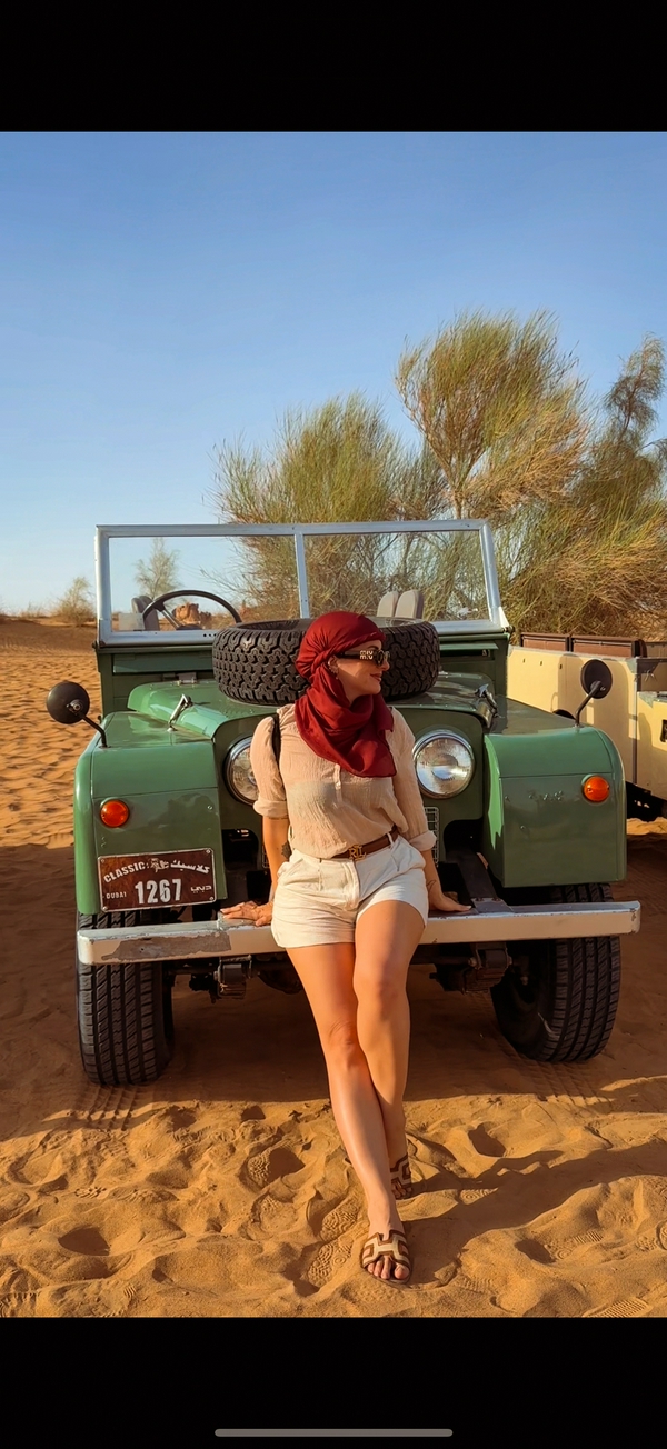 A vintage jeep navigating the sandy terrains of the Dubai Desert.