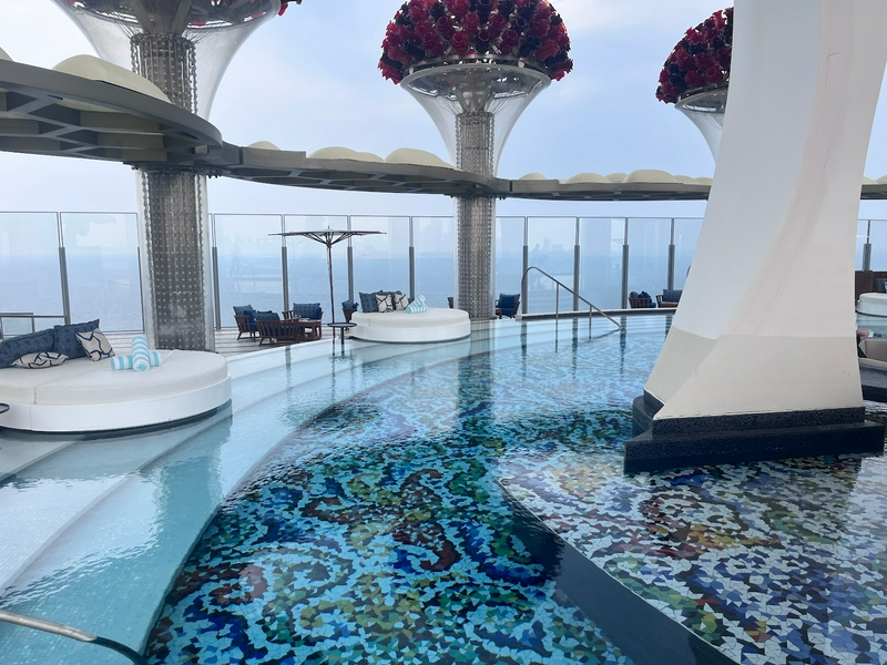 Luxurious pool area with lounge chairs and glass railing at Cloud 22 Dubai
