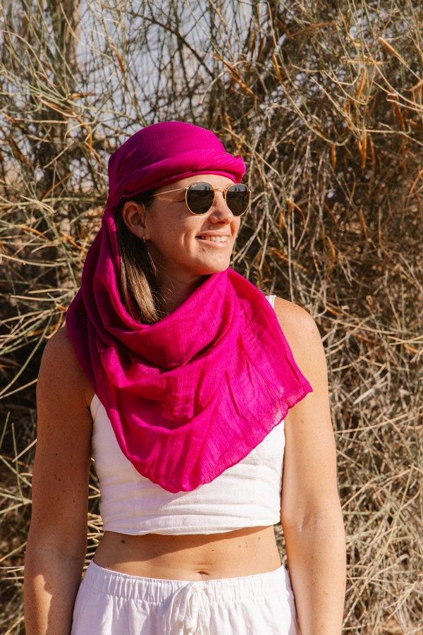 Traveler wearing sunglasses and a scarf in the desert sun.
