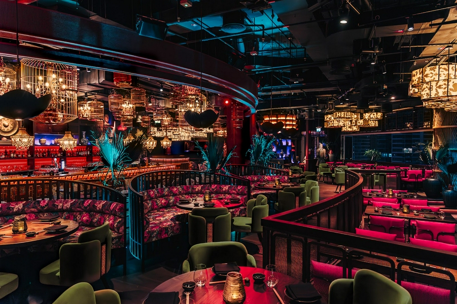 A cozy restaurant interior showcasing elegant lighting, stylish furniture, and artistic decor.