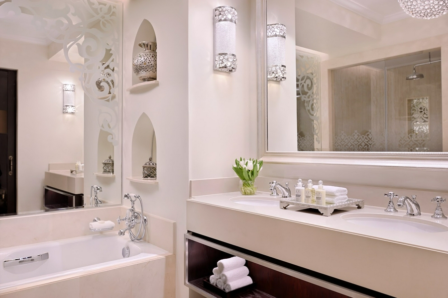 Luxurious hotel bathroom featuring a spacious bathtub, modern sink, and plush towels.