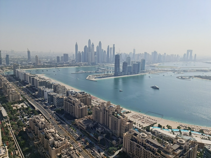 A vibrant cityscape of Dubai showcasing modern skyscrapers and serene waters of Palm Jumeirah.