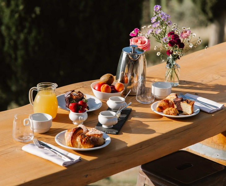 A vibrant outdoor breakfast setting in Tuscany with fresh fruits and pastries.