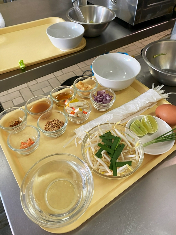 Participants enjoying a Thai cooking class with fresh ingredients.