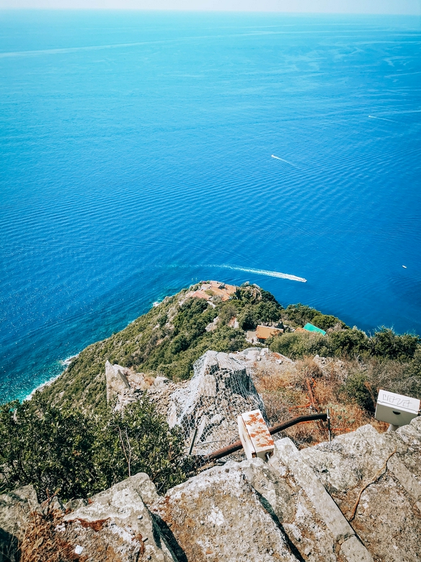 Coastal hiking path with views of the sea and terraced vineyards.