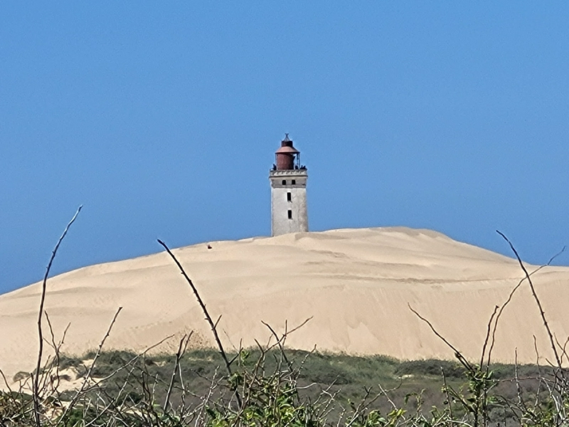 Rubjerg Knude Lighthouse partially buried in sand dunes, Denmark.
