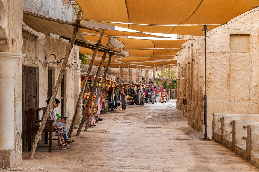Bustling market scene in Dubai Old City with vendors and shoppers.