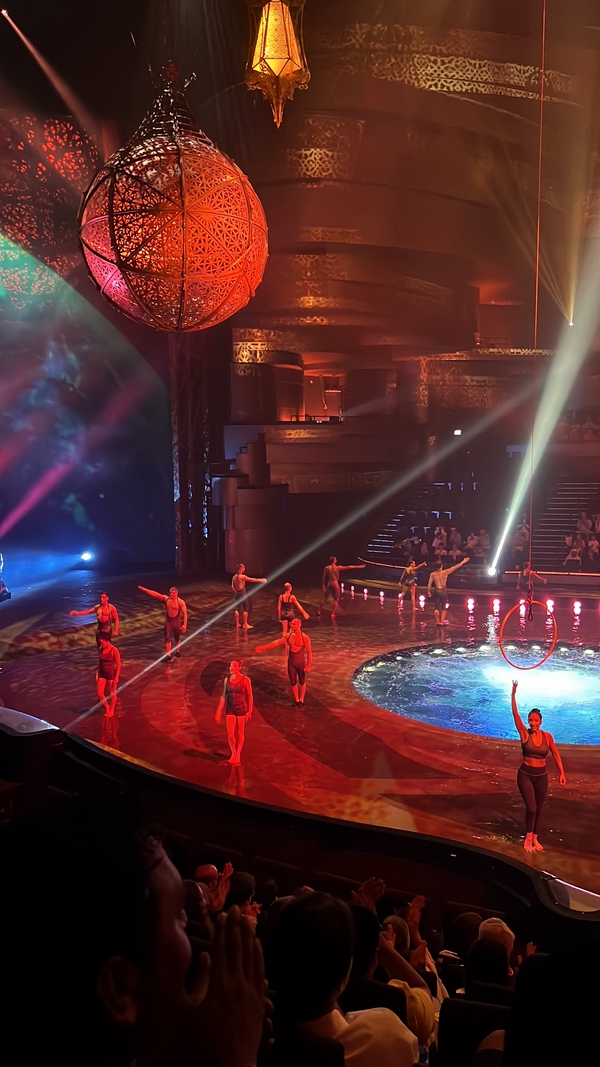 A vibrant stage showcasing a live performance with dynamic lighting and an engaged audience.