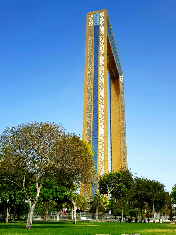 The Dubai Frame showcasing its unique design amidst trees and a park.