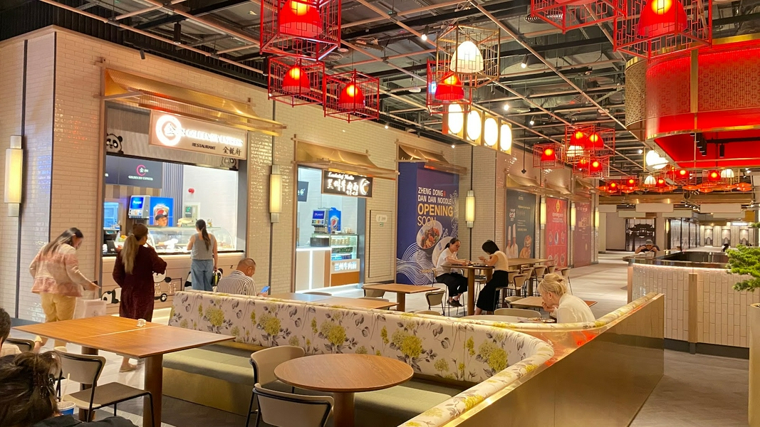 A vibrant food court in Chinatown Dubai Mall with diverse dining options and people enjoying meals.