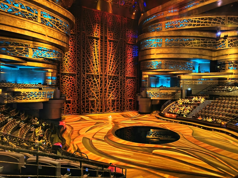 A vibrant theater stage set for a live performance with audience seating.
