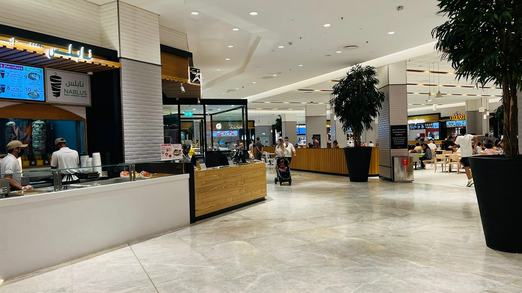 A bustling scene at Dubai Mall showcasing shoppers and dining areas.