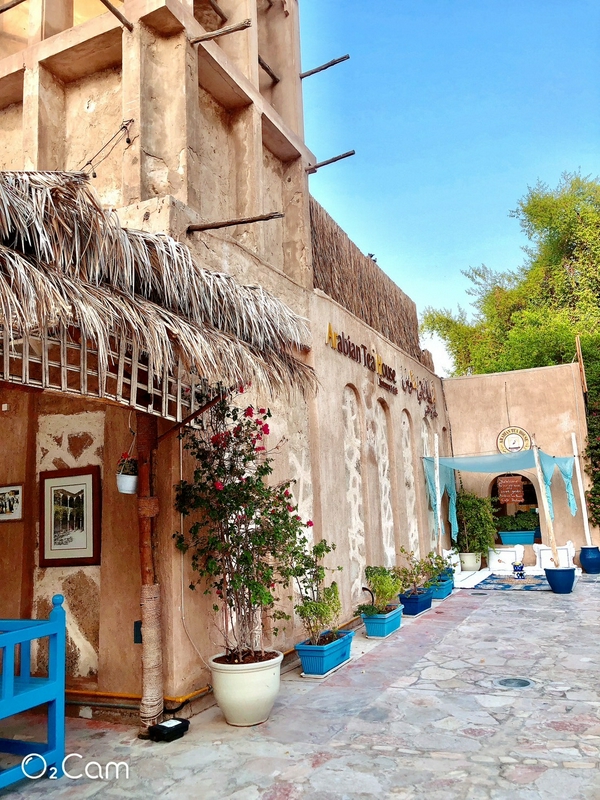 A beautiful courtyard in Dubai Old City showcasing traditional architecture and greenery.