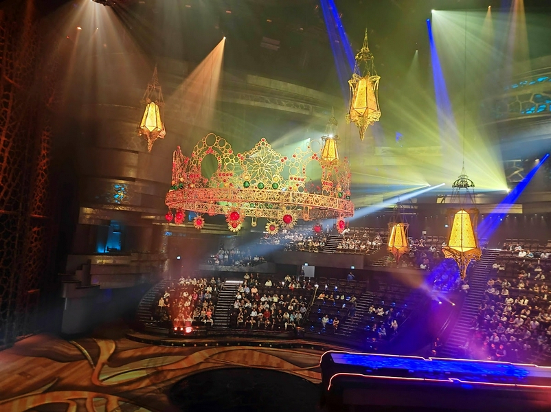 A captivating theater scene with a stunning chandelier and audience engaged in a live performance.