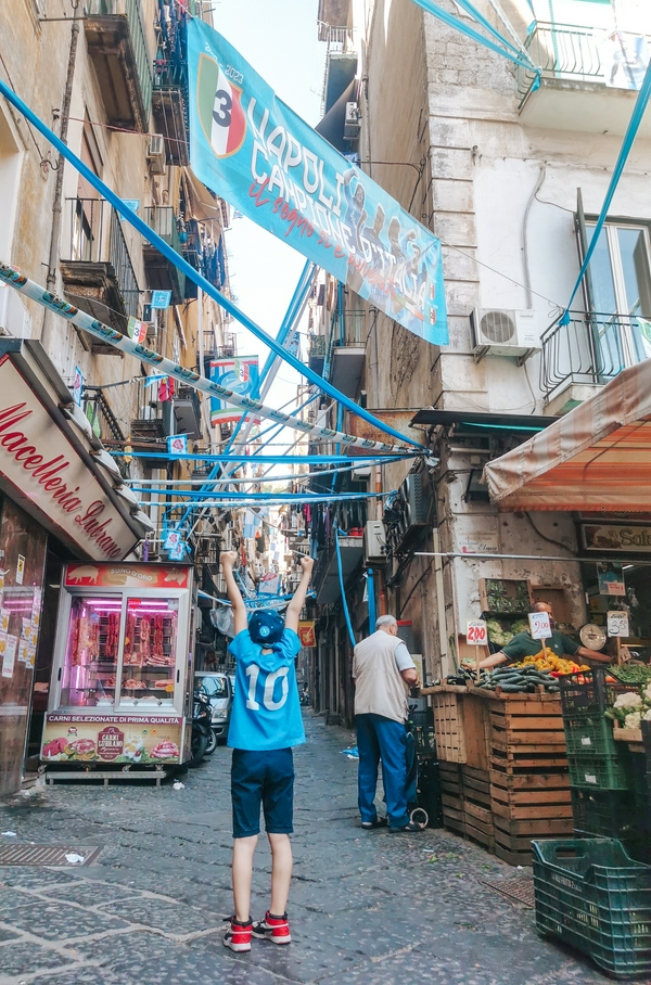Via Pignasecca market in Naples with festive decorations and lively atmosphere.