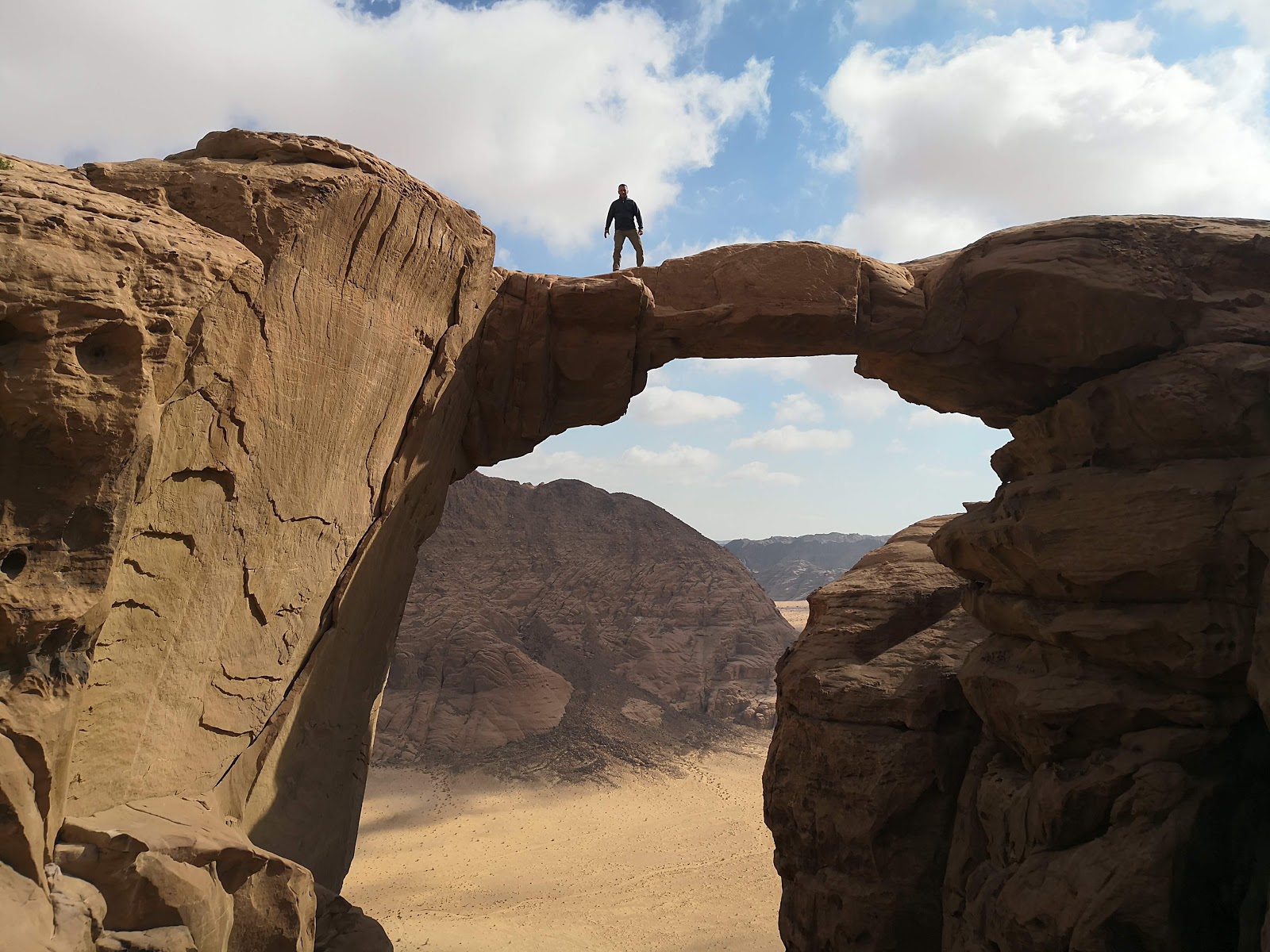 Hiking to Burdah Rock Bridge in Wadi Rum, showcasing stunning desert landscapes.
