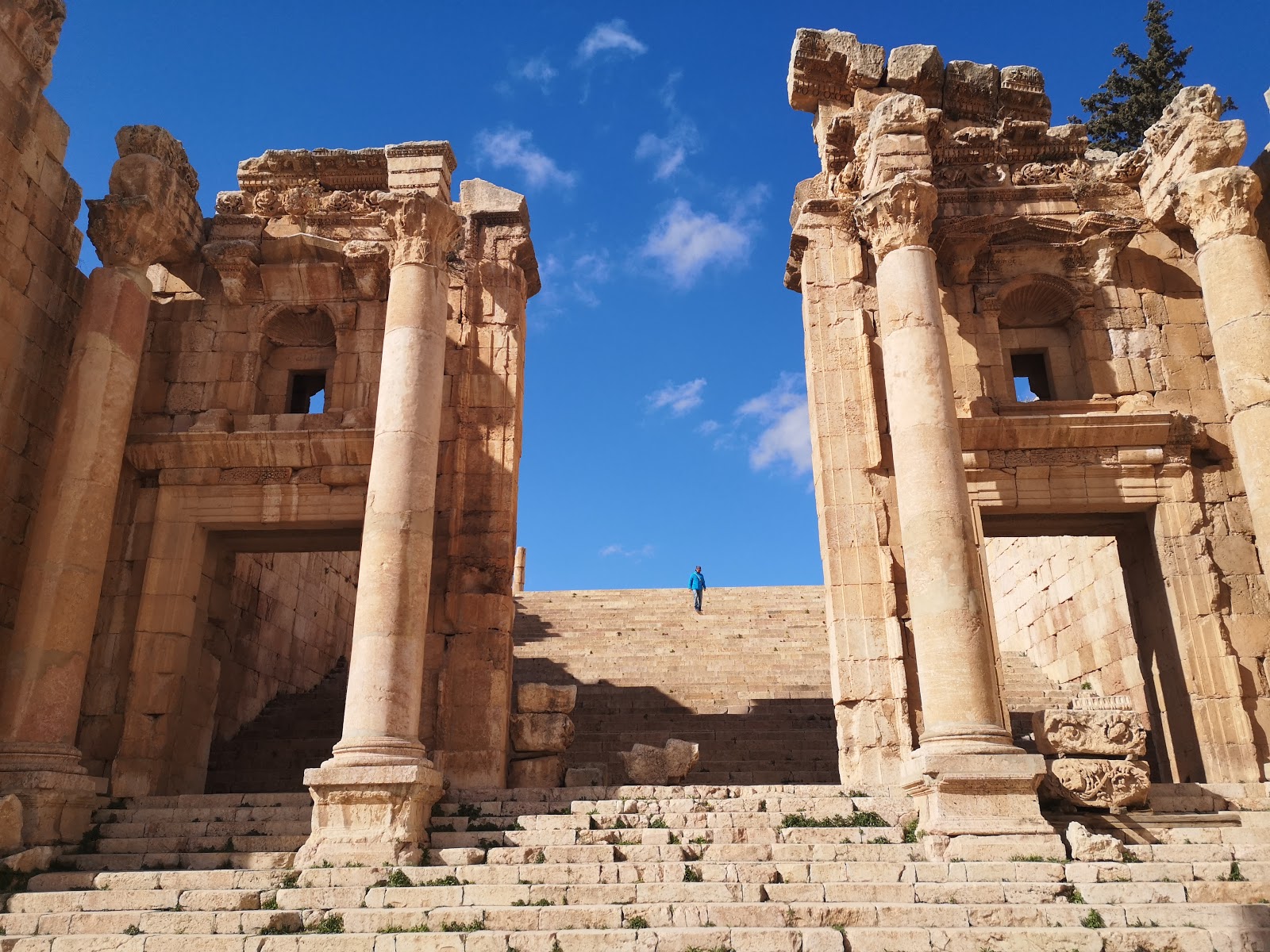Visitors exploring the outdoor archaeological ruins of Jerash.