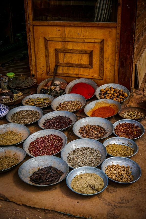 Colorful spices displayed in bowls at an outdoor market in Amman.