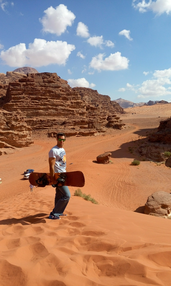 Vast desert landscape of Wadi Rum with unique rock formations and sunny skies.