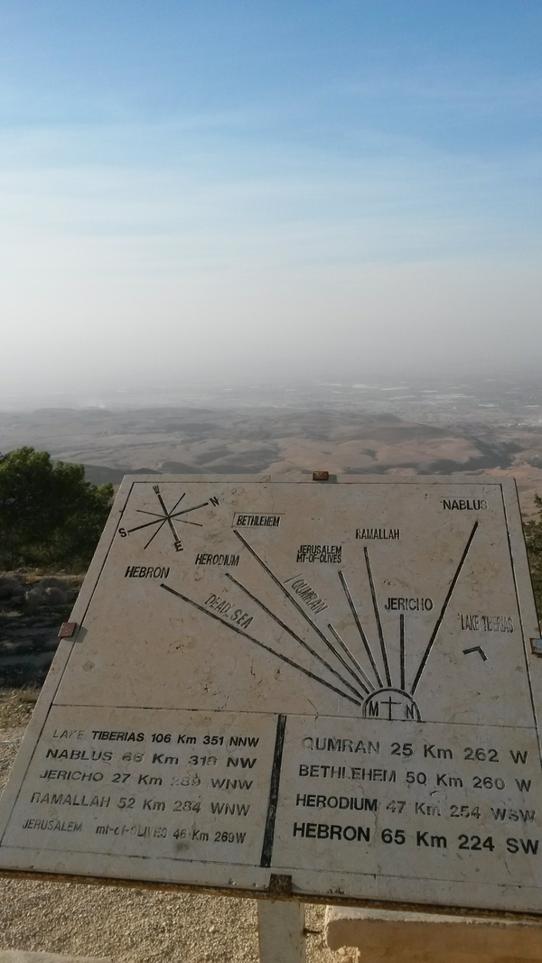 A picturesque landscape in Madaba with a prominent sign and clear sky.