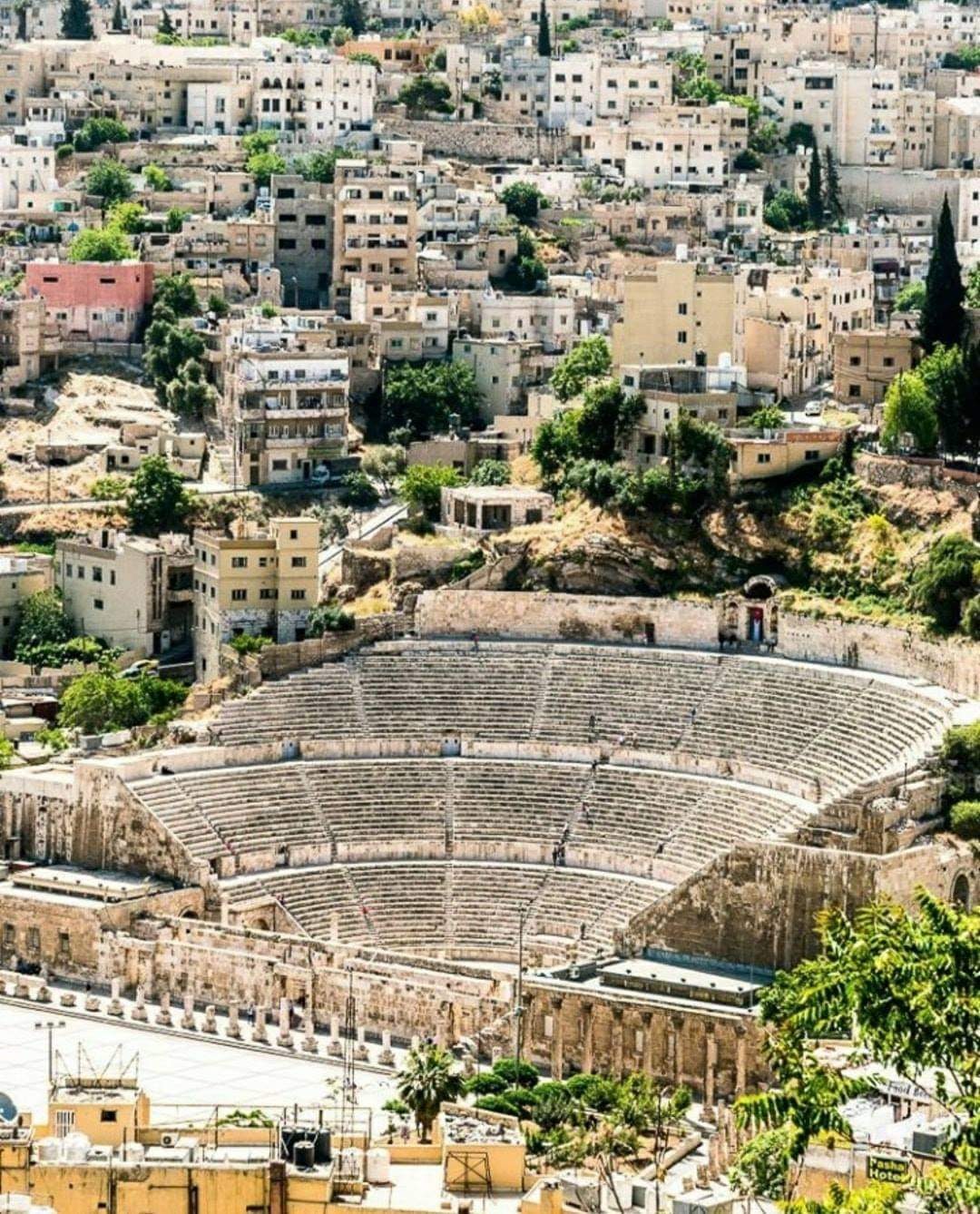 Visitors exploring the Roman Theater with cameras in an outdoor setting.