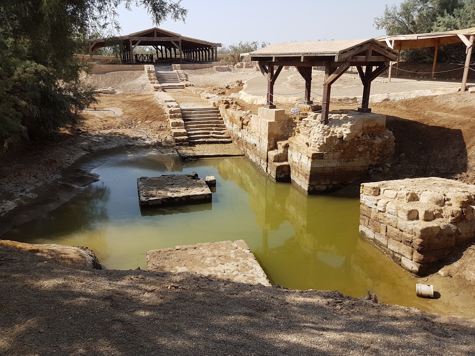 Visitors reflecting at the baptismal site of Jesus Christ near the Jordan River.