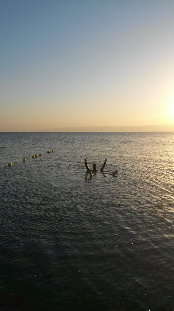 Vibrant sunset over the Dead Sea with hues of orange and pink.
