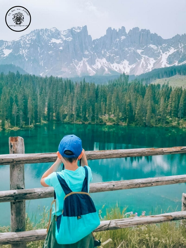 Lago di Carezza with reflections of the Latemar Massif and the statue of nymph Ondina.