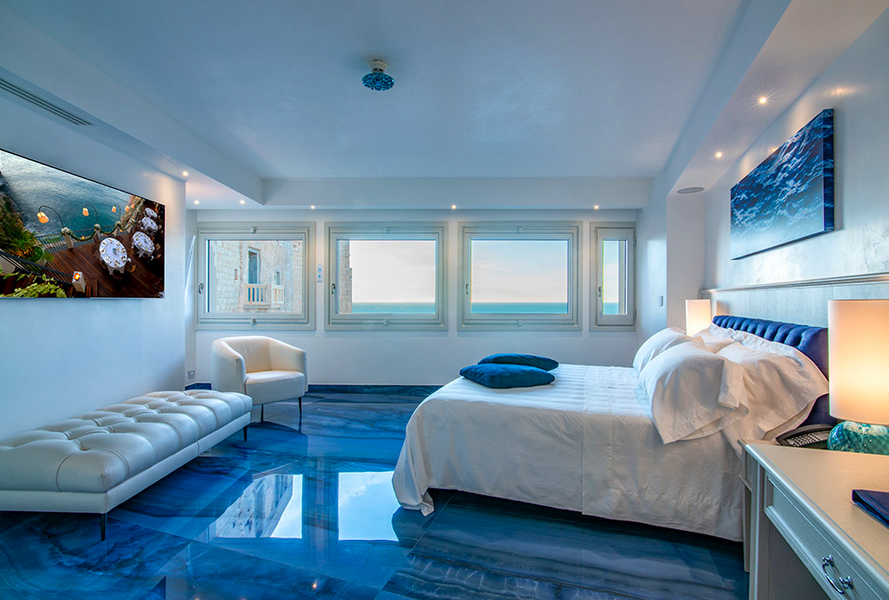 Well-decorated bedroom with stylish bed and ocean view window.