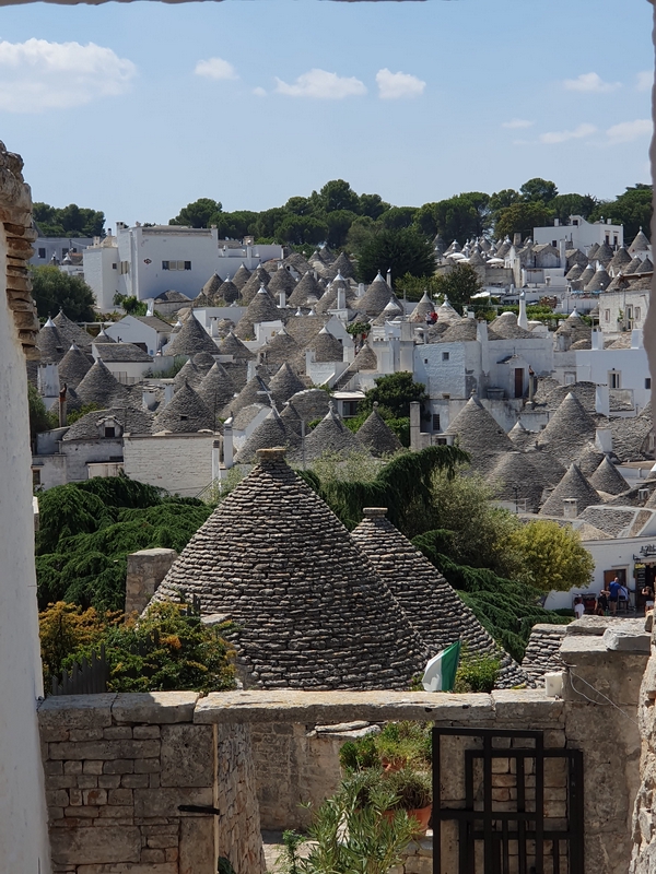 Trulli houses in Alberobello, a UNESCO World Heritage Site, surrounded by lush hills.
