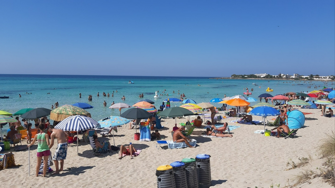 Punta Prosciutto Beach showcasing golden sand and clear blue sea.