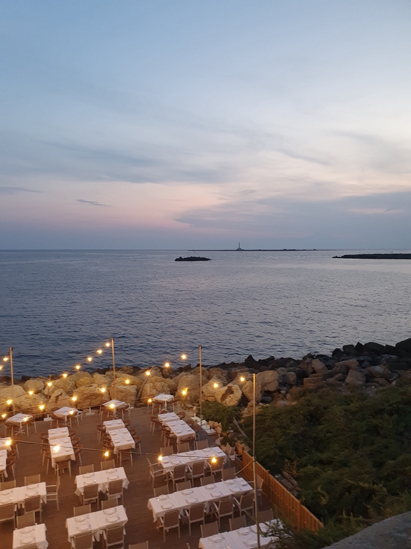 Ocean sunset in Gallipoli with outdoor dining and string lights