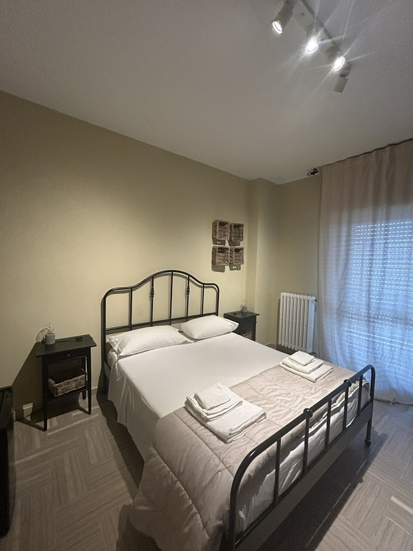 Cozy bedroom featuring stylish decor, a comfortable bed, and soft lighting.