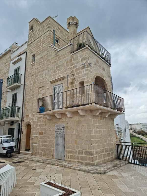 Prominent stone building with balcony in an urban landscape.