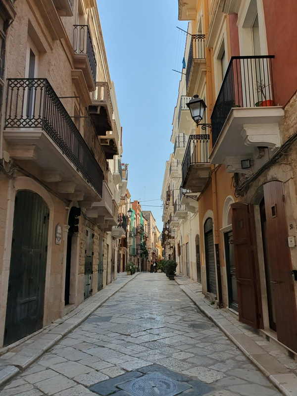 Vibrant street scene in Bari with lively shops and cafes.