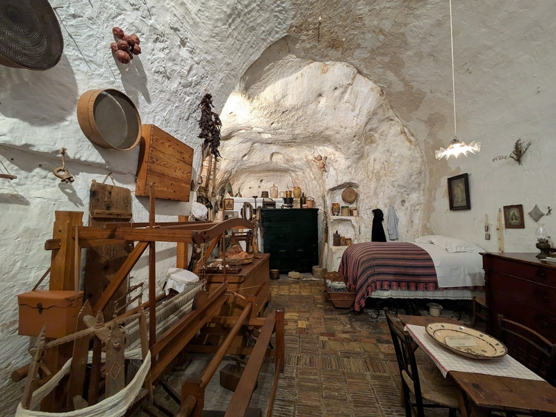 Interior view of Casa Grotta showcasing rustic wooden furniture and stone walls.