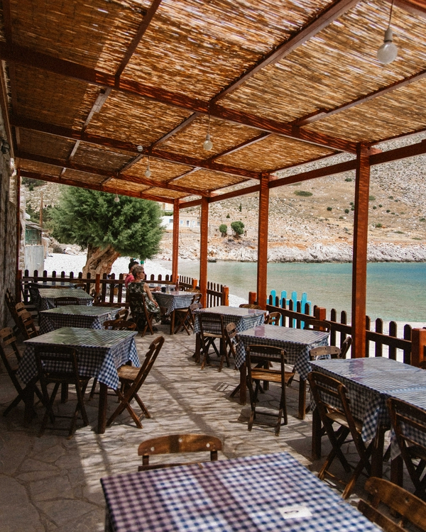 Outdoor dining setup with checkered tablecloth by the sea