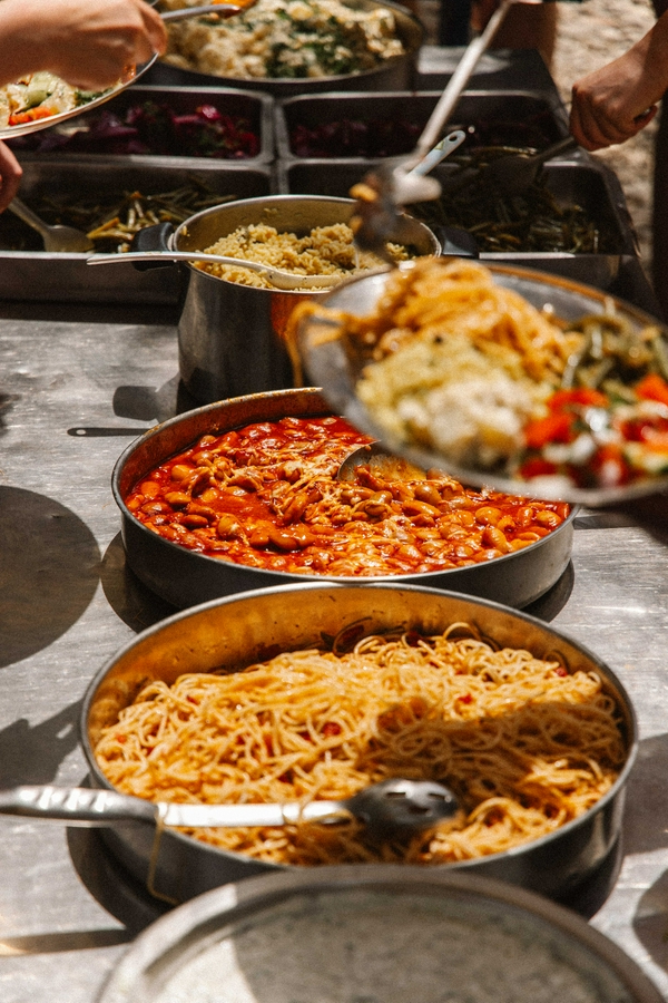 A buffet table showcasing a variety of pasta dishes.