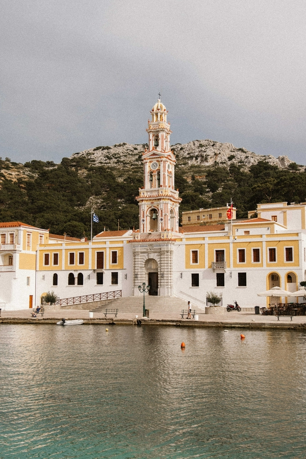 The Holy Monastery of the Taxiarch Michael Panormitis at a scenic waterfront on Symi island.